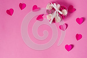 Paper pink hearts and a transparent box with pink and white rose buds with a satin bow and ribbon
