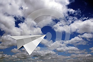 Paper plane flying in blue skies