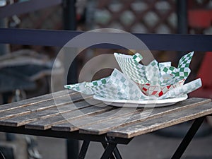 Paper plate with food truck and fast food wrappers and containers sitting on picnic table