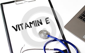 Paper plate, stethoscope and keyboard on the white background. VITAMIN E