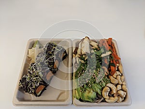  paper plate with sushi and vegetables