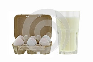 Paper pulp egg tray packages of fresh eggs next to glass of fresh pasteurized milk photo