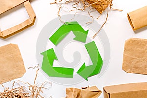 Paper recycle sign with paper and carton garbage on white background top view
