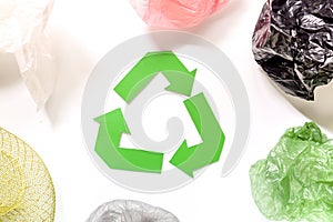 Paper recycle sign with plastic garbage on white background top view