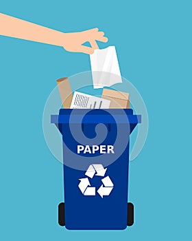 Paper recycling. Hand throwing a paper into a recycle bin.