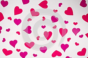 paper red and pink hearts of different sizes on a white background. Birthday card with copy space for Valentine`s day