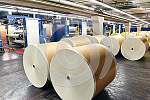 Paper rolls and offset printing machines in a large print shop for production of newspapers & magazines