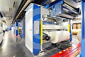 Paper rolls and offset printing machines in a large print shop for production of newspapers & magazines