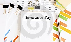 Paper with Severance Pay on a table with chart