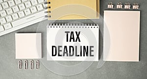 Paper sheet with text TAX DEADLINE, calculator photo