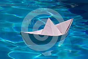 Paper ship , origami paper ship sail. Paper boat on the sea water background. Dreaming traveling.