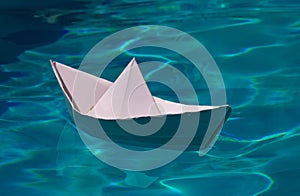 Paper ship , origami paper ship sail. Paper boat on the sea water background. Dreaming traveling.
