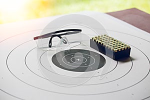 Paper shooting target with bullet and protection glassess