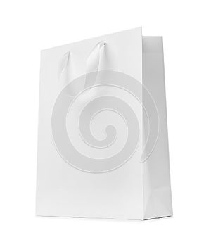 Paper shopping bag with ribbon handles on white background.