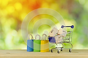 paper shopping bags and boxes in trolley on green yellow background Customer can buy everything from office or home