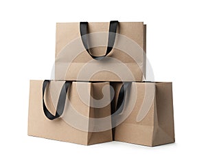 Paper shopping bags with ribbon handles on white background.