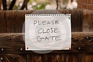 Paper sign attached to a timber gate