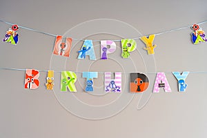Paper sign Happy Birthday with colorful monsters from virtual games on a gray background photo