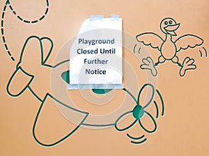 Paper sign at playground saying that playground is closed until further notice