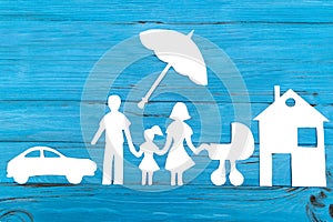 Paper silhouette of family with baby carriage under umbrella