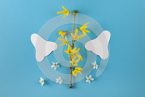 Paper silhouette of a nose and spring flowers