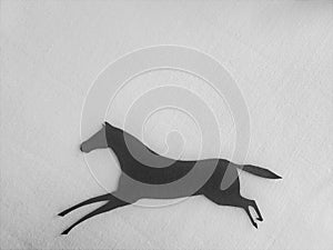 Paper silhouette of running horse on white background