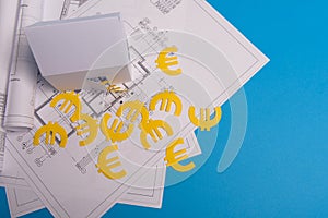 Paper skyscrapers , euro money, house projects plan and blueprints on blue background paper. Minimalistic and simple concept,