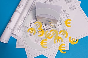 Paper skyscrapers , euro money, house projects plan and blueprints on blue background paper. Minimalistic and simple concept,