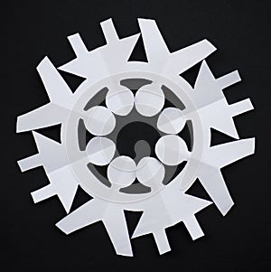 PAPER SNOWFLAKE CUT AS PEOPLE HOLDING THEIR HANDS