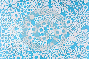 Paper snowflakes on blue background. Top view. Christmas decoration