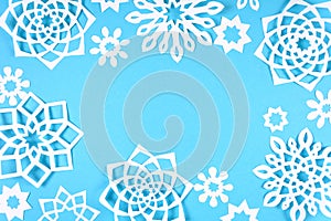 Paper snowflakes frame on blue background. Top view. Christmas decoration