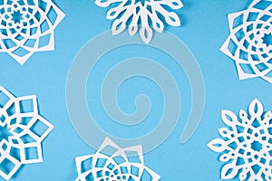 Paper snowflakes frame on blue background. Top view. Christmas decoration. Toned