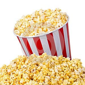 Paper striped bucket on a heap of popcorn isolated on white background