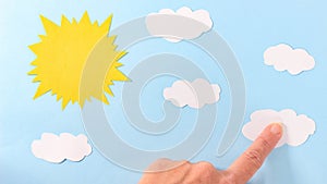 The paper sun and clouds in the paper sky are attached with a finger. Application