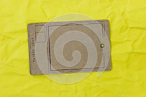 Paper tag on yellow crumpled paper background