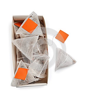 Paper tea bags with tags and box on white background, top view