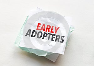 paper with text early adopters on white background photo