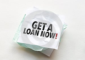 paper with text get a loan now on white background