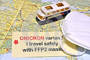 Paper with text `OMICRON Variant I travel safely with FFP2 masks` above map of Europe with ffp2 type protection masks and a mode