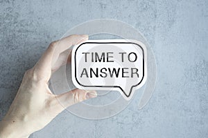 Paper with text TIME TO ANSWER in hand