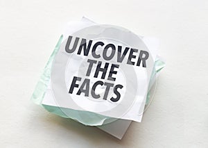 paper with text uncover the facts on white background