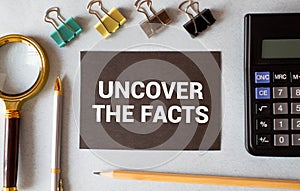 paper with text uncover the facts on white background