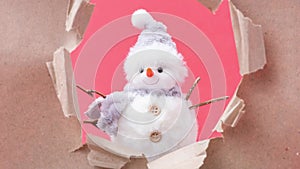 The paper is torn and a snowman appears on a red background. Christmas stop motion animation