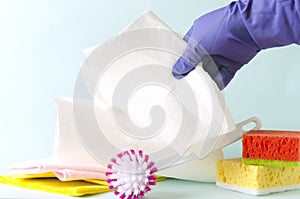 Paper towels rool and different cleaning items, cleaning lady taking paper towel for wiping dust.Concept of cleaning process