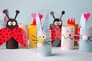 Paper toy Happy Easter home party. Easy crafts for kids on blue background, copy space, die creative idea from toilet tube roll,