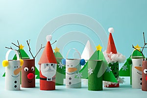 Paper toy Santa, Snowman, Grinch for Xmas party. Easy crafts for kids on blue background, copy space, die creative idea from