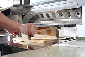 Paper trimming on a guillotine. Work in the printing house