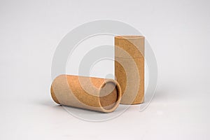 Paper tubes on grey background with copyspace - cardboard packaging for natural cosmetics and deodorant. Reusable packaging and