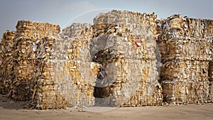 Paper Waste Stacked Before Shredding at Recycling Plant. A Pile of Compressed Paper Waiting To Be Recycled. Garbage Recycle