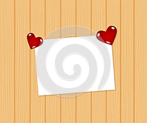 Paper on wooden background with heart paperweights photo